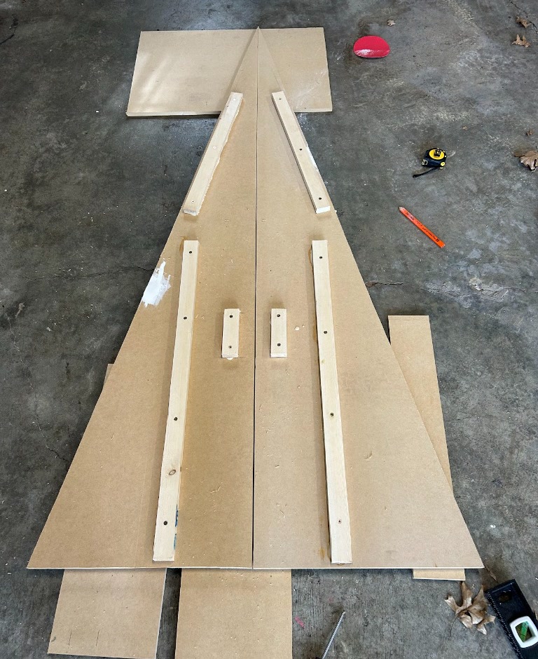 The two mirrored side panels laid flat on the garage floor with 1x2 pine cleats glued and screwed into position